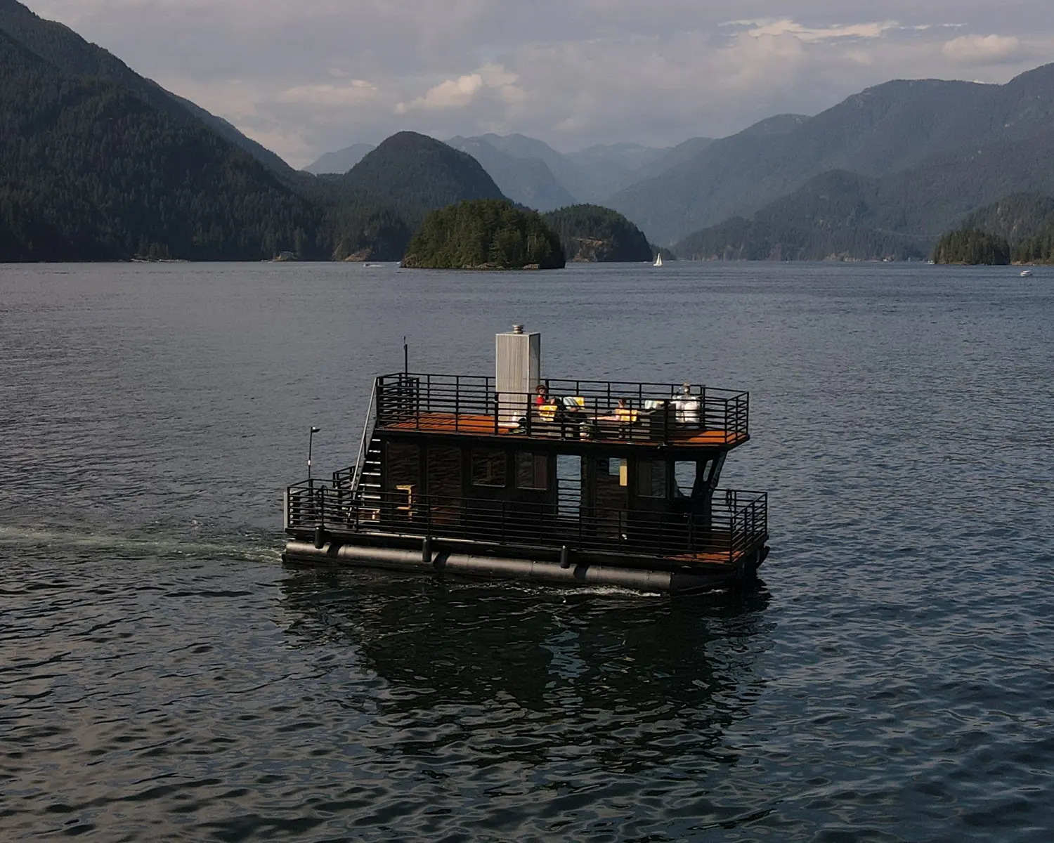 Aerial drone view of a 35ft luxury sauna boat on the glacial waters of Indian Arm fjord.