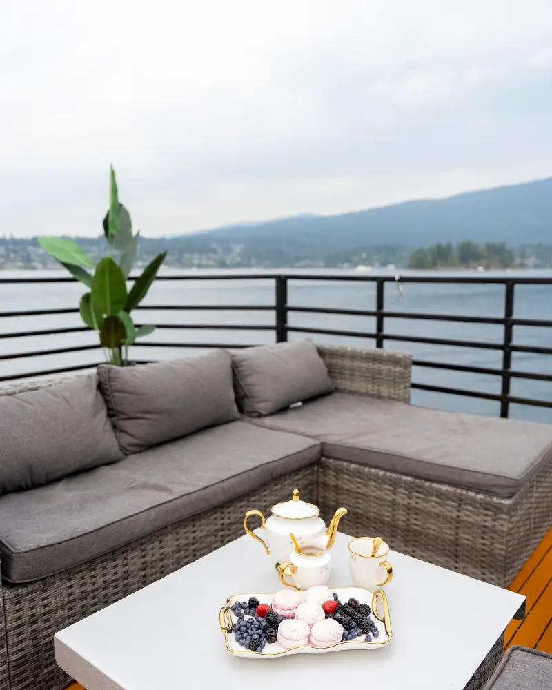 Luxury outdoor sectional sofa on the aft deck of a private charter boat, set with a porcelain tea and fresh berries.