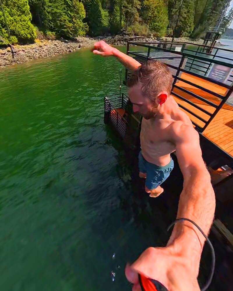 A man taking a selfie while jumping off the Hot Voyage sauna boat.