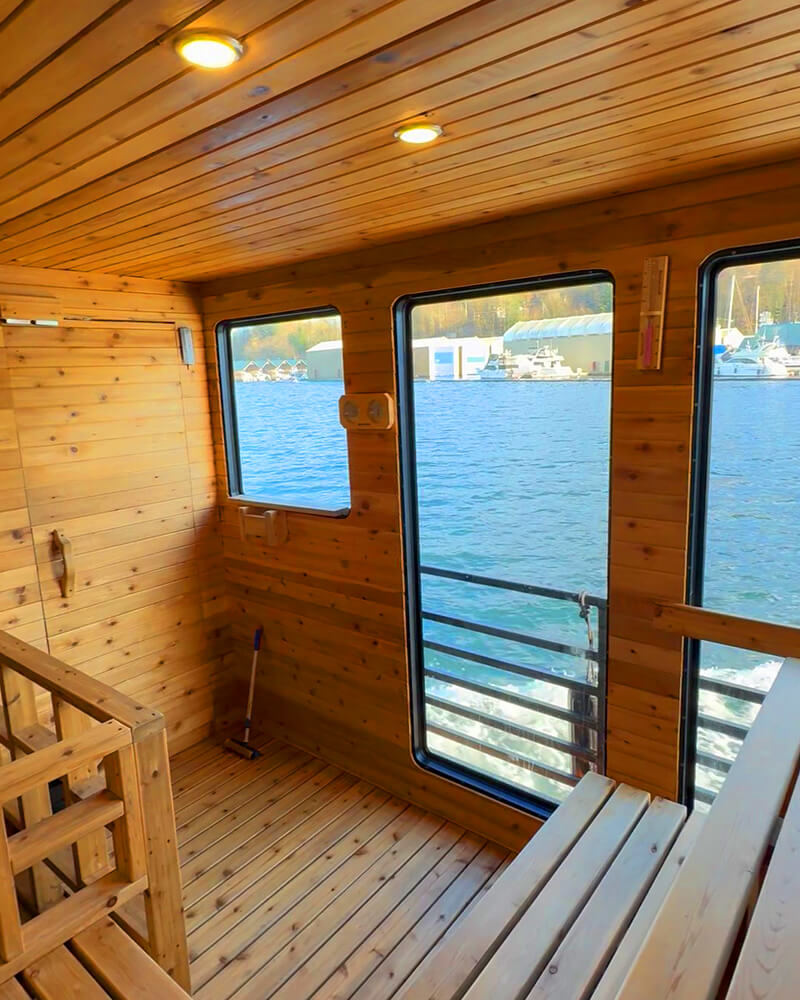 View of the ocean and mountains through the large window of the Hot Voyage sauna boat.