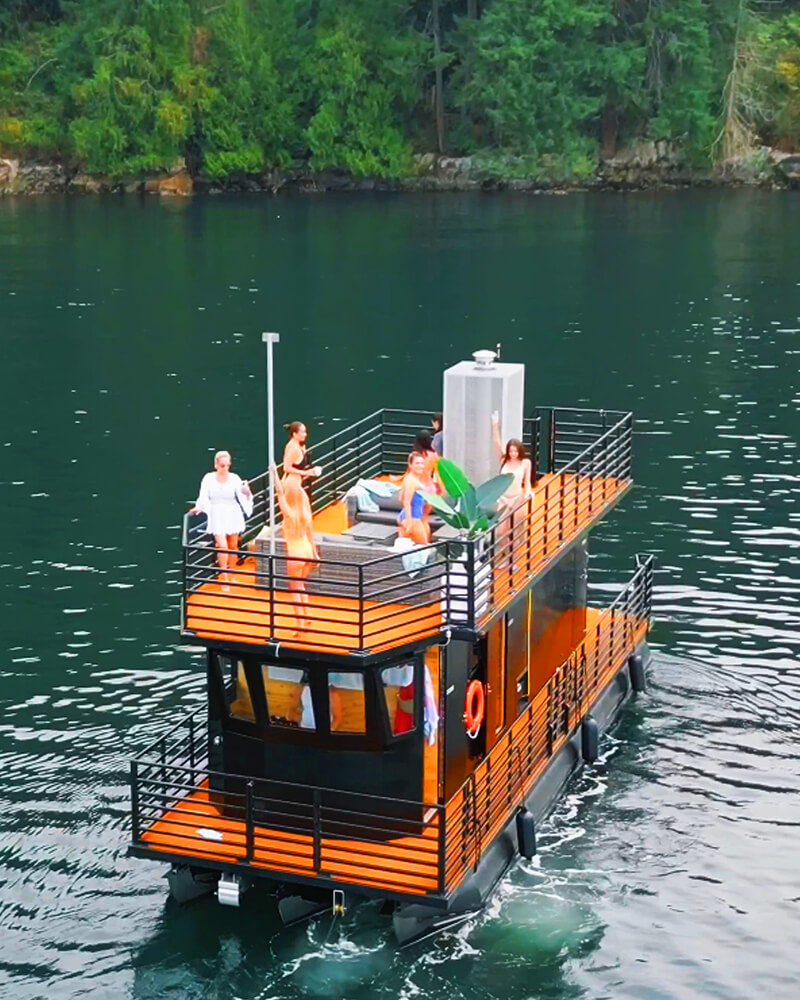 Aerial view of the Hot Voyage sauna boat anchored in calm waters.