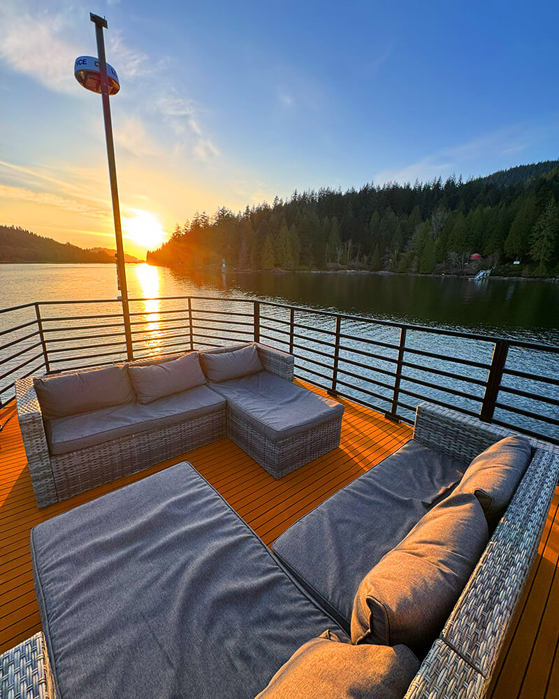Rooftop deck of the Hot Voyage sauna boat during a golden sunset.