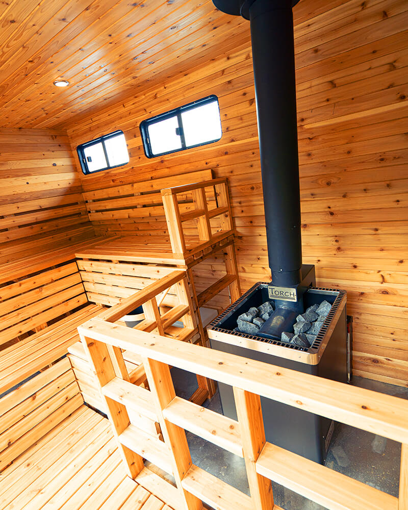High-quality sauna stove filled with rocks inside the Hot Voyage sauna boat.